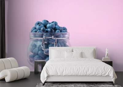 Blueberries in a glass bowl on a pink background, a berry in a glass jug. Vegetarian food concept. Wall mural