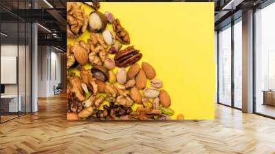 Flat lay ketogenic diet. A mix of walnut,pistachios,pecan and almond are laid out on the yellow background. Concept of healthy food.Copy space for mock up Wall mural