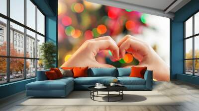 Heart from the hands in front of christmas tree Wall mural