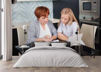 two women discussing documents at home Wall mural