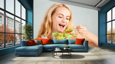 Young woman preparing vegetable salad Wall mural