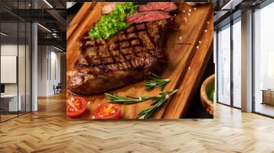 Grilled Black Angus Steak with tomatoes, garlic with chimichurri sauce on meat cutting board. Wall mural