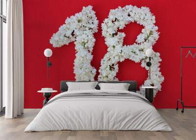 The number 18 is written in white lilac flowers on a red background. The number eighteen is written in fresh flowers, isolated on red. Arabic numeral lined with flowers. Wall mural