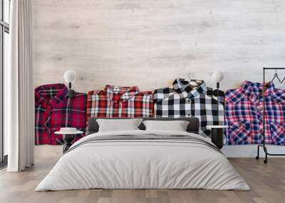 Four multi-colored checkered women's shirts lying neatly folded Wall mural