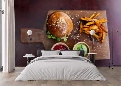 Fast food. Vegetarian burger with sweet potatoes fries and two sauces on wooden cutting board. Tasty sandwich for lunch in cafe. concept of health food. Top veiw Wall mural