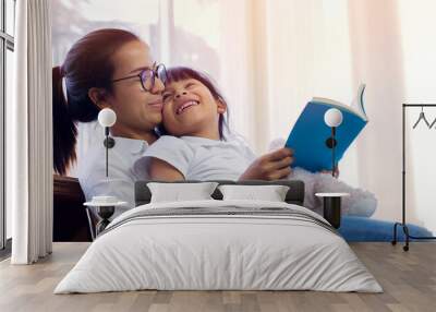 Asian children schoolgirl with mother reading books in library Wall mural