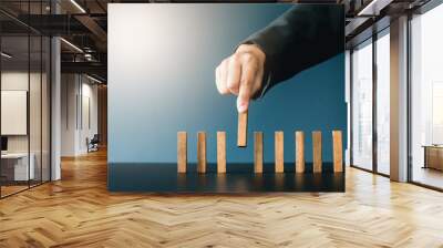 Close up of businessgirl hand Stopping Falling wooden Dominoes effect from continuous toppled or risk, strategy and successful intervention concept for business. Wall mural