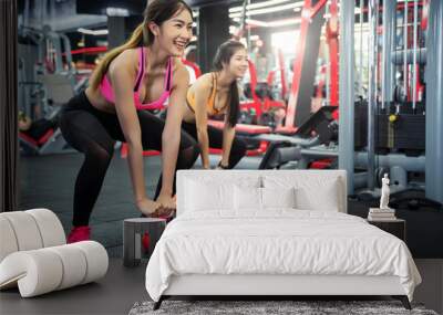 Young sport woman working out with kettle ball in gym. Healthy with fitness and exercise concept. Wall mural