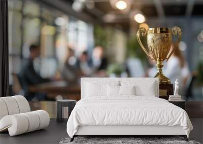 A golden trophy was placed on a table in front of an office. The trophy sits on the conference room table as the team celebrates in the background. Wall mural