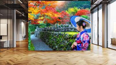 Asian woman wearing japanese traditional kimono in autumn park. Wall mural