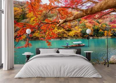 Boatman punting the boat at river. Arashiyama in autumn season along the river in Kyoto, Japan. Wall mural