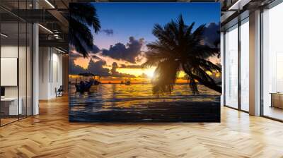 Tropical beach on sunset with silhouette palm trees. Wall mural