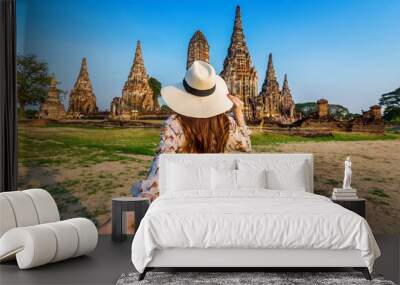 Woman holding man's hand and leading him to Ayutthaya Historical Park, Wat Chaiwatthanaram Buddhist temple in Thailand. Wall mural