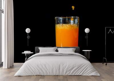 Pour orange juice into glass. Wall mural