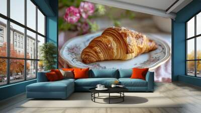 A croissant placed on a French porcelain plate, with a cafe setting background. Croissant day Wall mural