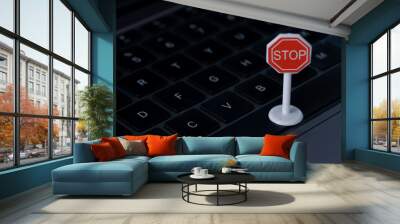 The image depicts a stop sign placed on a laptop keyboard, symbolizing the need to pause or halt online activity. Wall mural