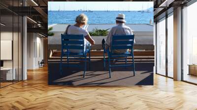 Cannes, France - September 11, 2015. A senior couple sitting on blue chairs and reads magazines in Cannes Wall mural