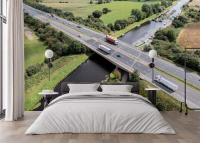 Aerial view directly above a busy UK motorway bridge spanning over a river Wall mural