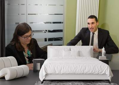 Three co-workers discussing business plan in office Wall mural