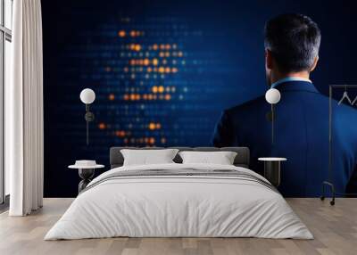 A businessman stands in front of a digital data visualization, reflecting on information and strategies in a modern office setting, showcasing technology and innovation. Wall mural