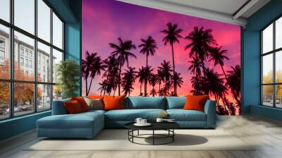 Silhouette of coconut trees against dramatic red sunset sky background. Wall mural