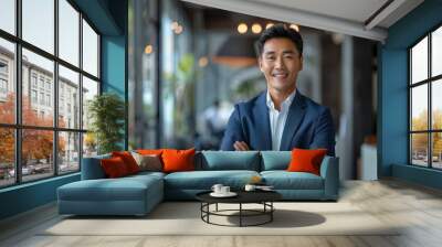 A young Asian businessman in a suit is smiling and posing for a picture Wall mural