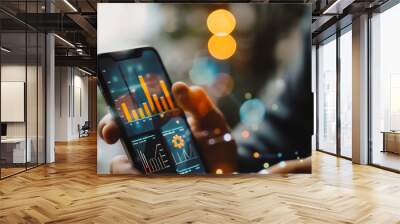 Businesswoman using smartphone to view reports, digital graphs, analyze market changes and investments Wall mural