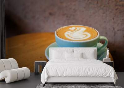 A cup of cappuccino coffee with soft foam on a wooden table. The coffee moment concept is everywhere. Wall mural