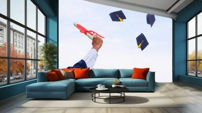 The right hand holds degrees in to sky. There is a hat throw in the sky. Show the success of education.  photo concept education and Success. Wall mural