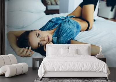 beautiful young girl posing on a white bed Wall mural