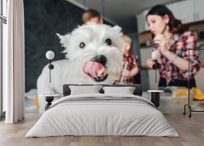 Dog on the kitchen table. Happy family in the kitchen Wall mural