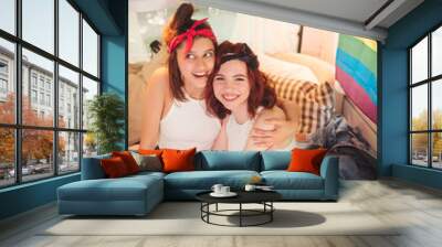 Portrait of a cute lesbian couple. Two girls spend time tenderly together in a camper trailer. Love and attitude. LGBT concept Wall mural