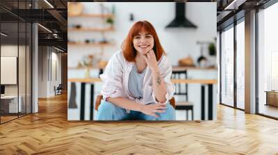 Woman sitting on a chair in a modern kitchen Wall mural