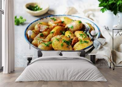 Young baked potato with bacon, spices and herbs in a baking dish on a gray background, still life Wall mural