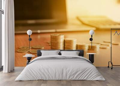 Stack of gold money coin on wood desk with calculator and pen. Business and financial concept.  Wall mural