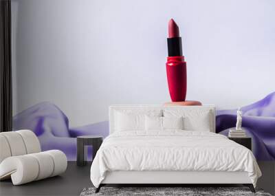 Red fashion lipstick and pink macaroons on purple silk fabric and gray background Wall mural