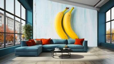 Two bananas on green pastel background. Food flat lay concept Wall mural