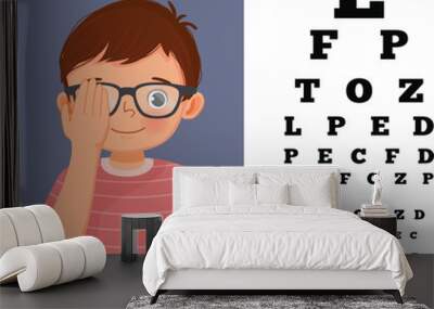 Cute little boy with eyeglasses cover his eye having vision test reading block letters at ophthalmologist office Wall mural