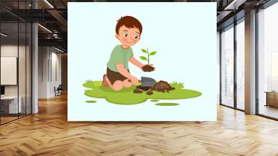 cute little boy with shovel planting young tree seedlings in the garden Wall mural