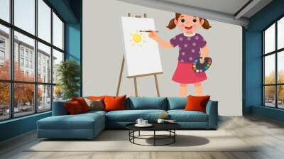 happy little girl artist holding color palette and paintbrush painting on the canvas  Wall mural