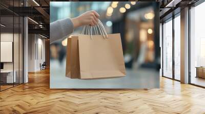 A person holding two brown paper shopping bags in a mall. Perfect for themes of shopping, retail, and commerce. Wall mural