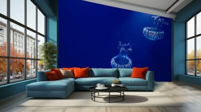 A pair of white spotted jellyfish floating in blue water with a spotlight shining down from above Wall mural