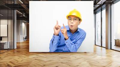 A happy, shocked asian consrtuction worker in blue shirt and yellow safety helmet pointing finger and presenting something ads.  Wall mural