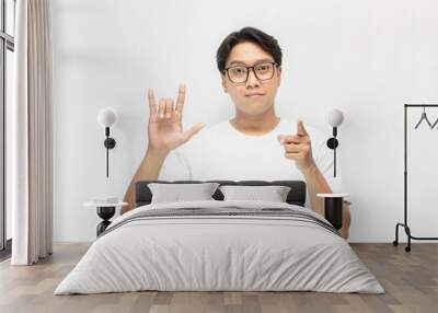 asian young man happily showing I love you gesture in sign language isolated over white background Wall mural