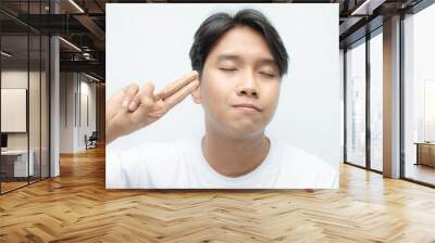 Close-up of a young asian man in white tshirt applying skincare cream to his face. skincare concept of asian man bare face. Wall mural