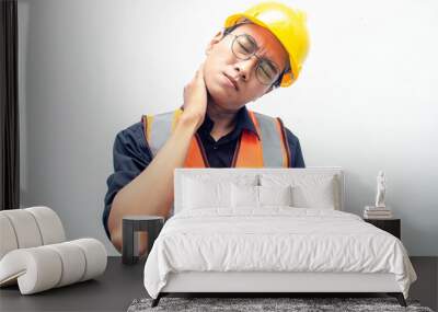 young asian male construction worker using yellow helmet and orange vest do stretching after hard working. stressed over work concept.  Wall mural