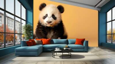 Cute panda baby isolated on light orange background with copy space on the side. Wall mural