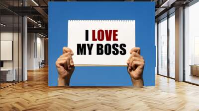 I love my boss text on box paper held by 2 hands with isolated blue sky background. This message board can be used as business concept about boss. Wall mural