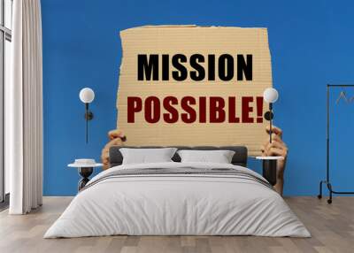 Mission possible on box paper held by 2 hands with isolated blue sky background. This message board can be used as business concept about informing people that anything is possible. Wall mural