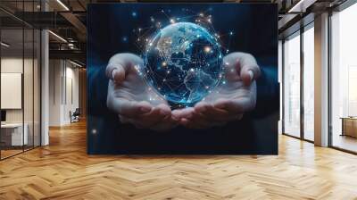 A person holds a glowing digital globe, symbolizing global connectivity and technological advancement in a dark environment Wall mural